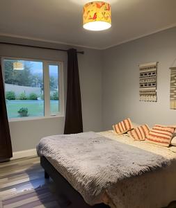 a bedroom with a large bed and a window at Casa Rural con opción de tina temperada in Puerto Varas