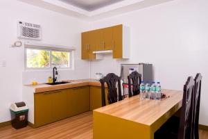 eine Küche mit einem Holztisch und einem Kühlschrank in der Unterkunft E&C Tourist Inn in Dumaguete