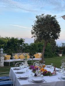 a table with a white table cloth and a tree at Villa Neptunus in Ischia