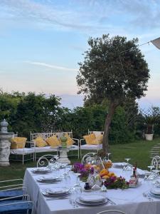 una mesa con un mantel blanco y un árbol en Villa Neptunus, en Isquia