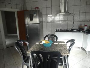 a kitchen with a table with chairs and a refrigerator at Pedroca Hostel in Palmas