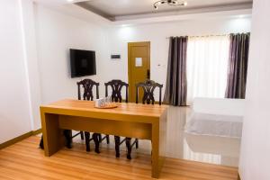 ein Esszimmer mit einem Tisch und einem Bett in der Unterkunft E&C Tourist Inn in Dumaguete