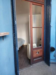 puerta a un baño con cama y espejo en Habitación en suite en el centro de Buenos Aires. en Buenos Aires