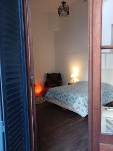 1 dormitorio con 1 cama, 1 silla y 1 ventana en Habitación en suite en el centro de Buenos Aires. en Buenos Aires