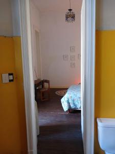 布宜諾斯艾利斯的住宿－Habitación en suite en el centro de Buenos Aires.，客房设有床和带黄色墙壁的浴室