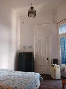 布宜諾斯艾利斯的住宿－Habitación en suite en el centro de Buenos Aires.，一间卧室配有一张床、一扇门和吊灯
