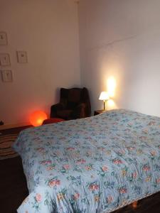 布宜諾斯艾利斯的住宿－Habitación en suite en el centro de Buenos Aires.，一间卧室配有一张床、一把椅子和一盏灯