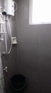 a bathroom with a black toilet and a window at Argao Aballe Pension House/Apartelle in Argao