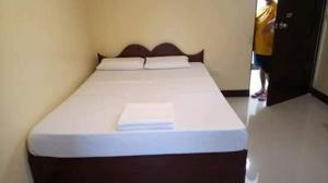 1 cama grande en una habitación con una persona de pie junto a ella en Argao Aballe Pension House/Apartelle en Argao