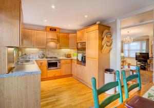a large kitchen with wooden cabinets and a table at Beach Mews in Torquay