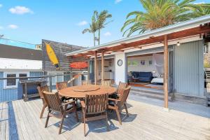 a wooden table and chairs on a deck at Boatshed in Huskisson