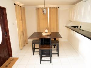 a kitchen with a table and chairs in a room at Sunset Cove Barbados in Christ Church