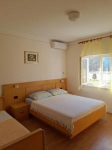una camera da letto con due letti e una finestra di Apartments with parking space Kampor, Rab - 4984 a Rab
