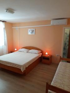 a bedroom with a bed and two lamps on tables at Apartments with a parking space Kampor, Rab - 4984 in Rab