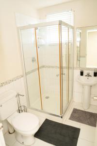 ein Bad mit einer Dusche, einem WC und einem Waschbecken in der Unterkunft Sunset Cove Barbados in Christchurch