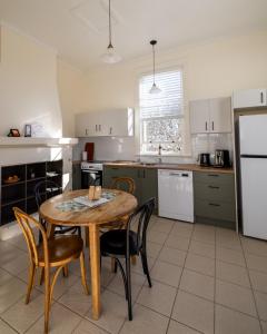 a kitchen with a table and chairs and a refrigerator at Seal Rocks Lighthouse Cottages in Seal Rocks