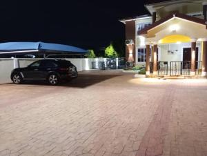 un coche aparcado delante de una casa por la noche en A world of your Own, en Dodowa