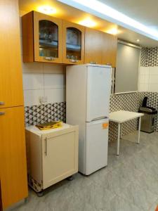 a kitchen with a white refrigerator and a table at A world of your Own in Dodowa