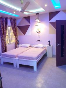 1 Schlafzimmer mit 2 Betten und lila Wänden in der Unterkunft A world of your Own in Dodowa