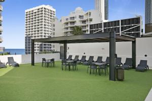 a group of chairs and tables on a roof at Sleek and Central Studio Apartment in Gold Coast