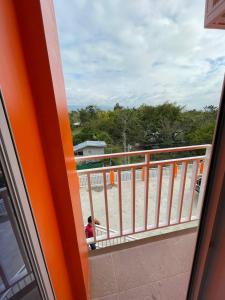 un bambino seduto su un balcone affacciato sulla spiaggia di Moalboal-Aballe Pension house a Moalboal