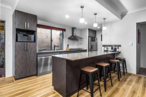 a kitchen with a bar with stools in it at Halls Head Beach Haven - Dogs welcome in Mandurah