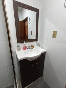 y baño con lavabo y espejo. en Apartamento cómodo en Potosí