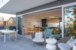 a living room and dining room with sliding glass doors at Salty Kisses by Experience Jervis Bay in Huskisson