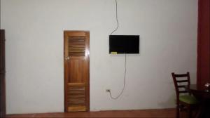 a television on a wall next to a wooden cabinet at 31 ave home stay in Managua