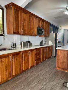 una cocina con armarios de madera y electrodomésticos de acero inoxidable en Casa Serena's Perfect Surfing Retreat, en Esterillos