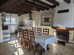 cocina con mesa, sillas y chimenea en Gîte Jouy-le-Potier, 3 pièces, 4 personnes - FR-1-590-54, en Jouy-le-Potier