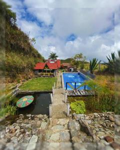 a house with a pool and a boat in the water at Hostal Camino Viejo in Líbano