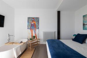 - une chambre avec un lit et une baignoire à côté d'un lavabo dans l'établissement Lussuosa Villa di Design in Sicilia con Piscina e Vista Mare Relax e Comfort a 5 stelle, à Ragalna