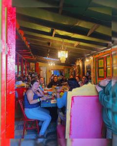 eine Gruppe von Menschen, die an einem Tisch in einem Restaurant sitzen in der Unterkunft Hostal Camino Viejo in Líbano