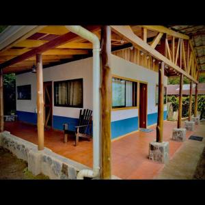une terrasse couverte d'une maison avec une table et des chaises dans l'établissement Casa Típica La Cruz, à Monteverde Costa Rica