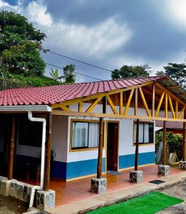 une petite maison avec un toit rouge dans l'établissement Casa Típica La Cruz, à Monteverde Costa Rica