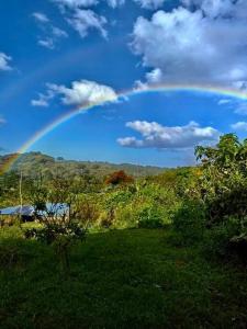 a rainbow in the sky over a green field at Casa Típica La Cruz in Monteverde Costa Rica +14 photos