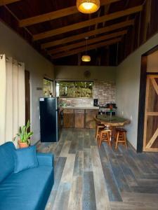 Il comprend un salon avec un canapé bleu et une cuisine. dans l'établissement Casa Típica La Cruz, à Monteverde Costa Rica