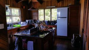 a kitchen with a white refrigerator and a counter top at Sere Ni Ika in Matei