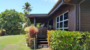 a house with a porch and some bushes at Sere Ni Ika in Matei