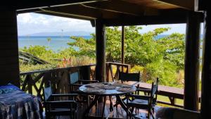 - une table sur une terrasse couverte avec vue sur l'océan dans l'établissement Sere Ni Ika, à Matei