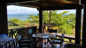 a table on a porch with a view of the ocean at Sere Ni Ika in Matei