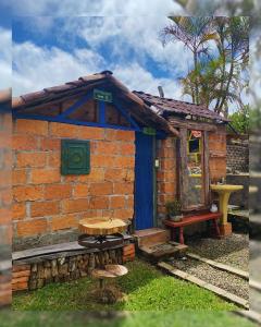 um edifício de tijolos com uma porta azul e um banco em Hostal Camino Viejo em Líbano