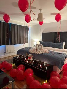 a room with red balloons and a bed with a table at Canary Wharf Apartments in London