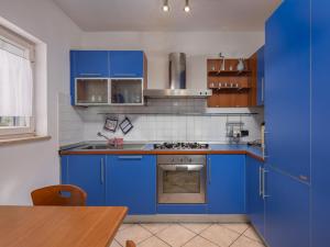 eine blaue Küche mit blauen Schränken und einem Tisch in der Unterkunft Apartments with a parking space Kostrena, Rijeka - 14285 in Kostrena