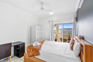 a bedroom with a bed and a desk and a window at Cairns City Apartments in Cairns