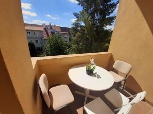 a small white table and chairs on a balcony at Villa Vinohrady in Prague