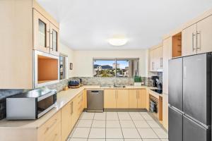 a large kitchen with wooden cabinets and stainless steel appliances at Cairns City Apartments in Cairns