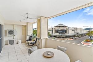 a balcony with a table and chairs and a view of a city at Cairns City Apartments in Cairns