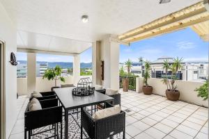 a patio with a table and chairs on a balcony at Cairns City Apartments in Cairns